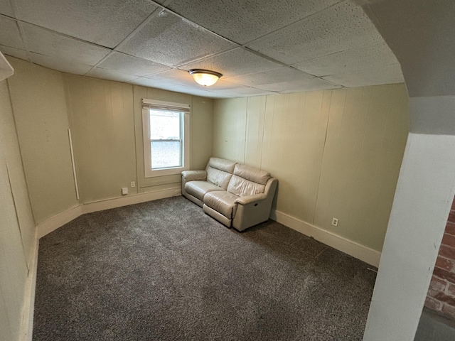 unfurnished room with dark colored carpet and a paneled ceiling