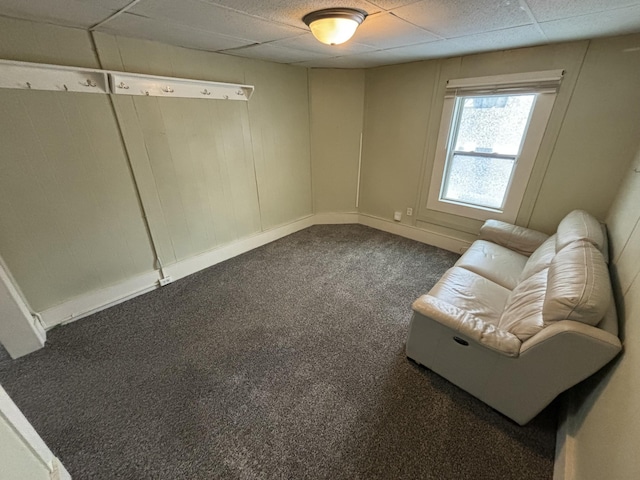 unfurnished room with a drop ceiling and dark carpet