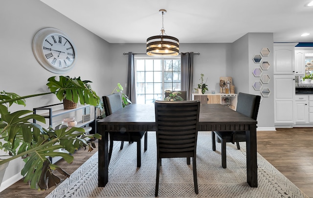 dining room with dark wood-type flooring and a notable chandelier