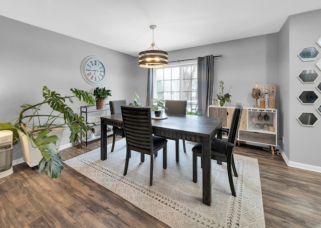 dining area with a chandelier and dark wood-type flooring