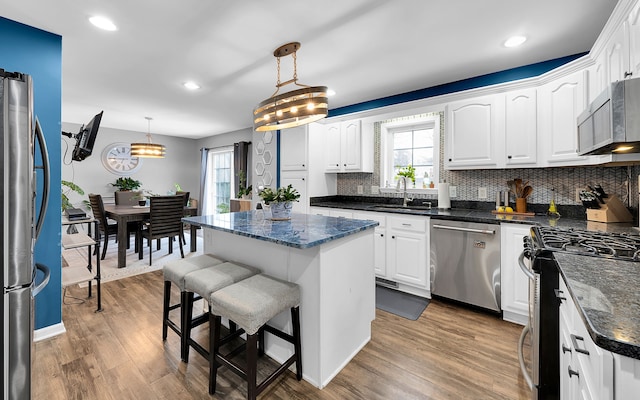 kitchen with white cabinets, a kitchen island, and stainless steel appliances