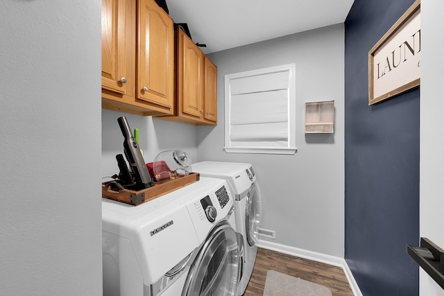 washroom featuring cabinets, dark hardwood / wood-style floors, and washing machine and dryer