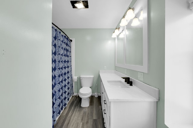 bathroom with hardwood / wood-style floors, vanity, toilet, and walk in shower