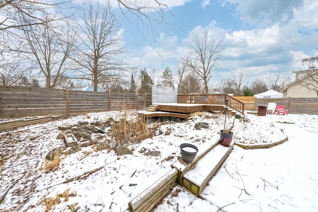 yard layered in snow with a deck