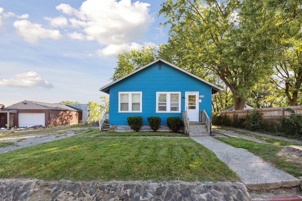 view of front of property featuring a garage and a front lawn