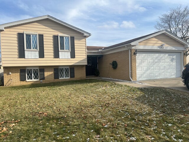 tri-level home featuring a garage and a front lawn