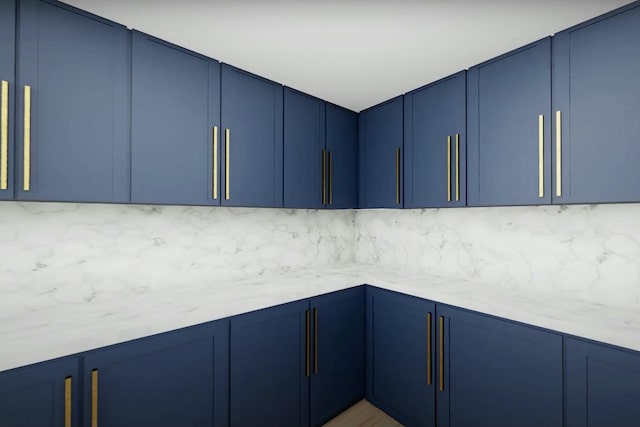 kitchen with blue cabinetry and light stone counters