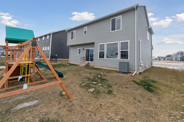 back of property with a yard, a playground, and central AC unit