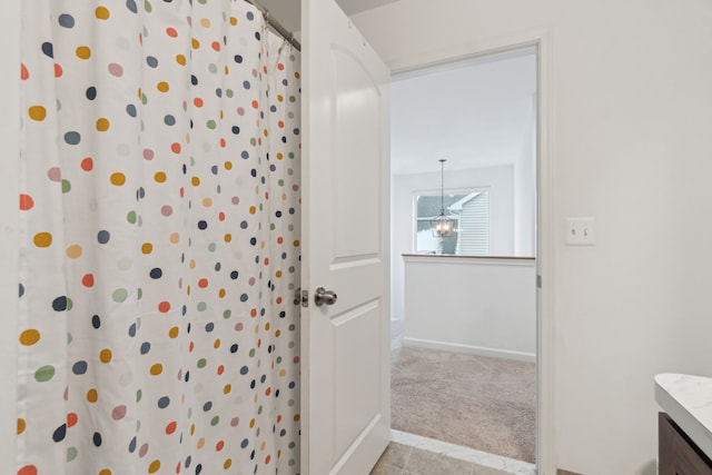 bathroom featuring a shower with curtain, vanity, and an inviting chandelier