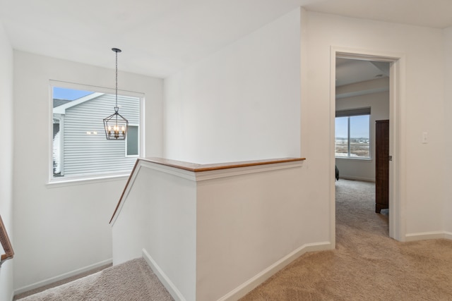 stairway featuring carpet floors and an inviting chandelier