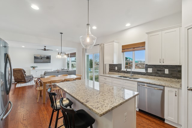 kitchen featuring white cabinets, a center island, stainless steel appliances, and sink