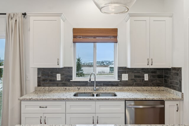 kitchen with tasteful backsplash, white cabinetry, sink, and stainless steel dishwasher