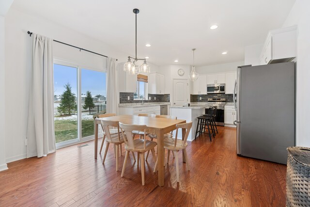 dining room with sink and dark wood-type flooring