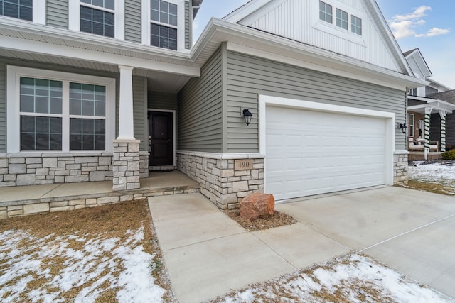 snow covered property entrance featuring a garage