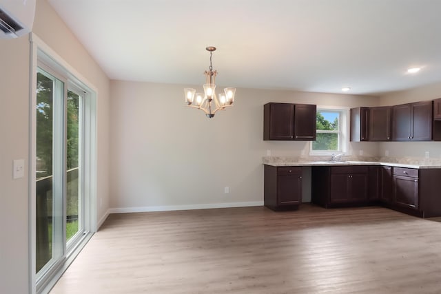 704 Eden St, Kingsley, MI 49649 - kitchen featuring light wood-style floors, an AC wall unit, a chandelier, dark brown cabinetry, and recessed lighting
