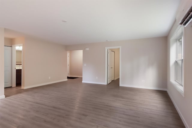 704 Eden St, Kingsley, MI 49649 - spare room featuring dark wood-type flooring and a wall mounted air conditioner