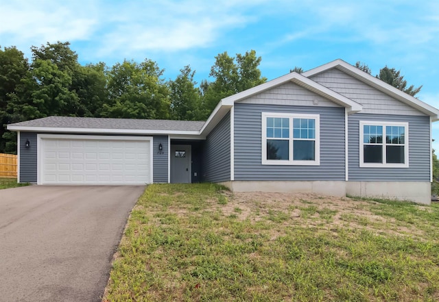 704 Eden St, Kingsley, MI 49649 - ranch-style house with asphalt driveway, a garage, and a front yard