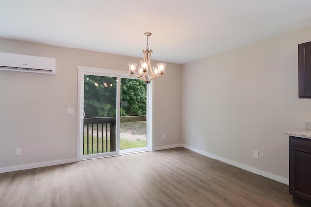 704 Eden St, Kingsley, MI 49649 - unfurnished dining area featuring a wall unit AC, wood finished floors, and a chandelier