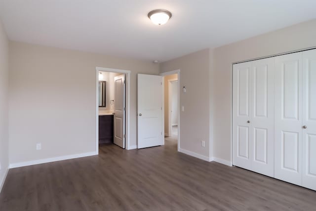 704 Eden St, Kingsley, MI 49649 - unfurnished bedroom with dark wood-style floors, a closet, and connected bathroom