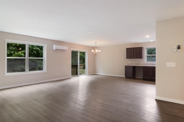 704 Eden St, Kingsley, MI 49649 - unfurnished living room featuring a wall mounted AC, a chandelier, dark wood-type flooring, and recessed lighting