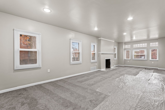 unfurnished living room with plenty of natural light and carpet floors