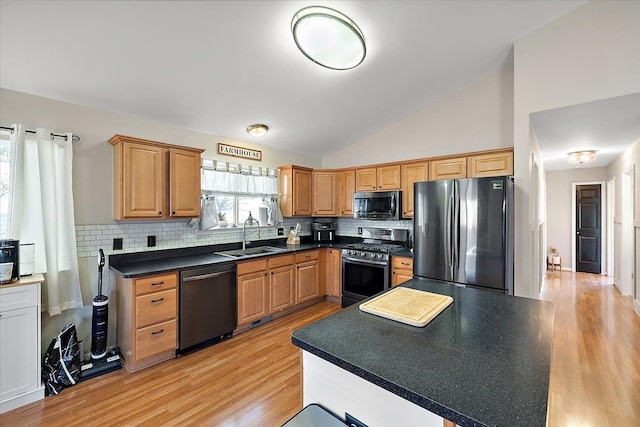 kitchen featuring high vaulted ceiling, sink, light wood-type flooring, appliances with stainless steel finishes, and tasteful backsplash