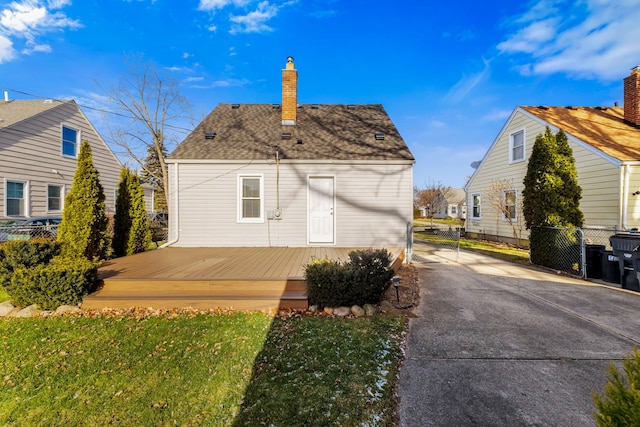 rear view of house with a lawn and a deck