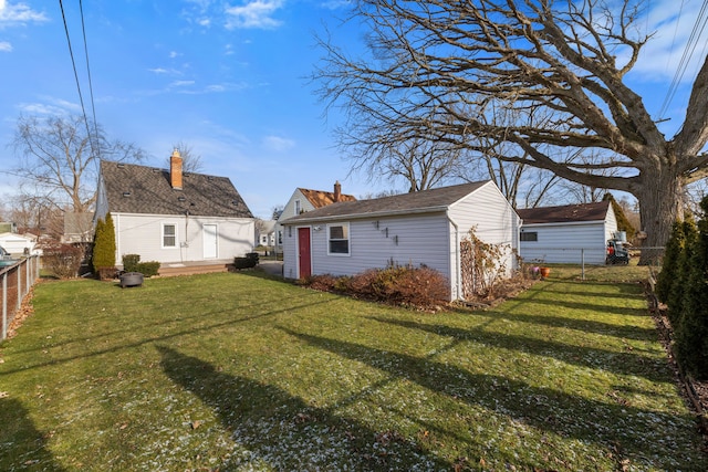 rear view of house featuring an outbuilding and a yard