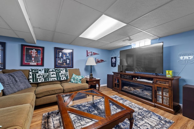 living room featuring a paneled ceiling and hardwood / wood-style floors