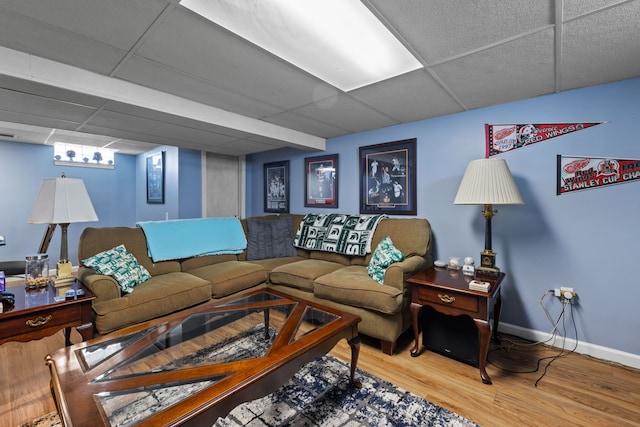 living room with a paneled ceiling and wood-type flooring