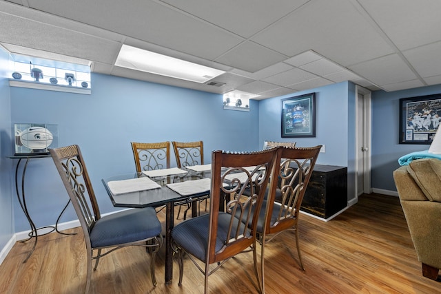 dining area with hardwood / wood-style flooring and a drop ceiling