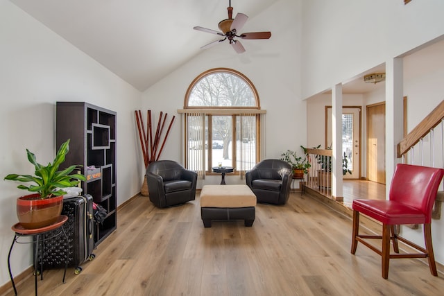 living area featuring ceiling fan, light hardwood / wood-style floors, plenty of natural light, and high vaulted ceiling