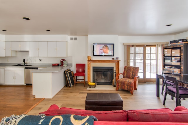 living room featuring sink and light hardwood / wood-style flooring