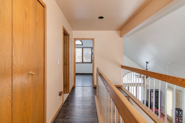 hall with vaulted ceiling and dark wood-type flooring