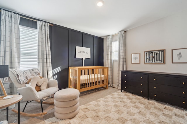 carpeted bedroom featuring a crib