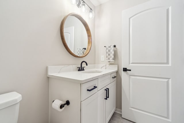 bathroom with tile patterned flooring, vanity, and toilet