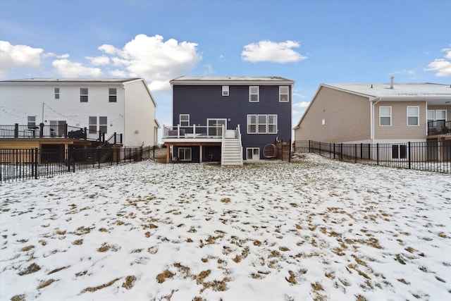 snow covered rear of property with a wooden deck