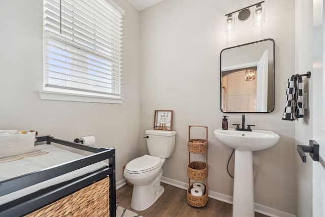 bathroom with hardwood / wood-style flooring, toilet, and sink