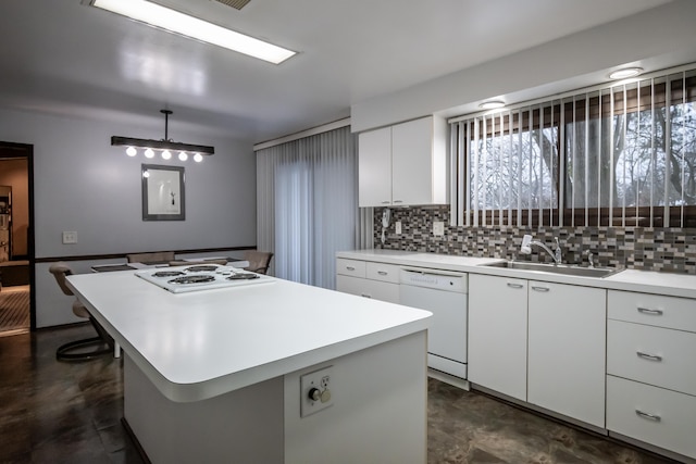 kitchen with white appliances, decorative light fixtures, a breakfast bar area, white cabinetry, and sink