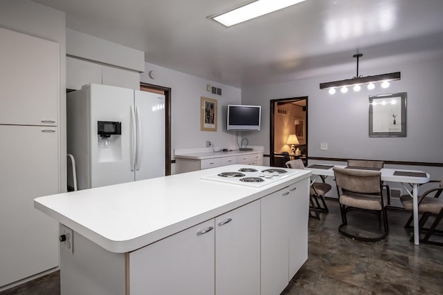 kitchen featuring white appliances, pendant lighting, and white cabinetry