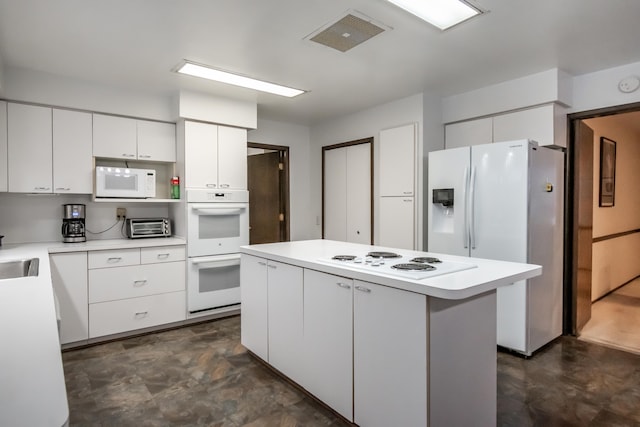 kitchen featuring sink, white appliances, white cabinetry, and a center island