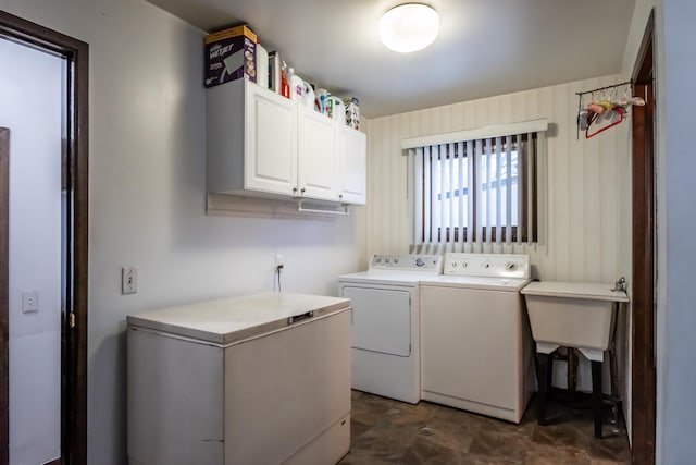 clothes washing area with washing machine and dryer and cabinets