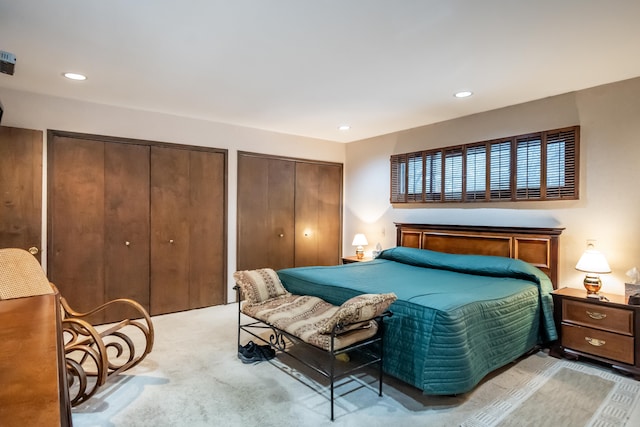 bedroom featuring two closets and light carpet