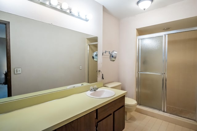 bathroom with toilet, walk in shower, and vanity