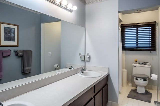 bathroom featuring toilet, vanity, and tile patterned flooring