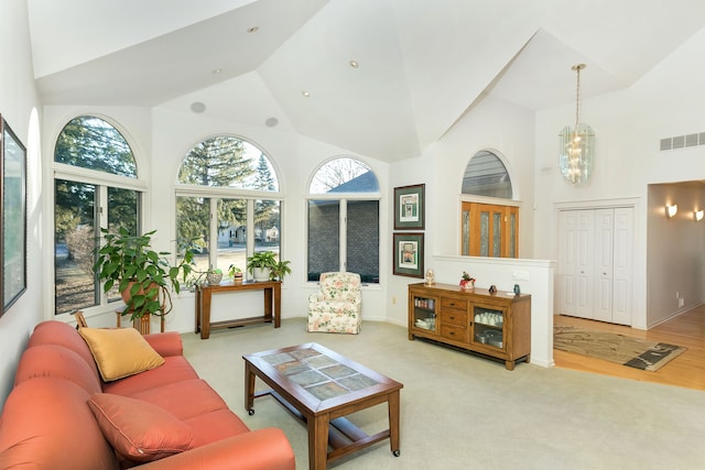 living room with light colored carpet and high vaulted ceiling