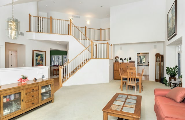 living room featuring a notable chandelier, a high ceiling, and carpet