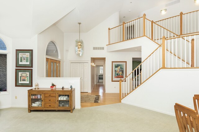 carpeted entryway with a towering ceiling