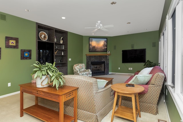 carpeted living room featuring a premium fireplace and ceiling fan