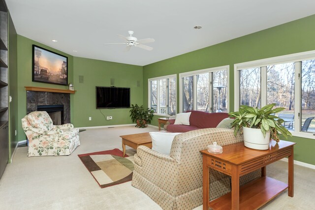 living room featuring ceiling fan, a fireplace, light colored carpet, and plenty of natural light